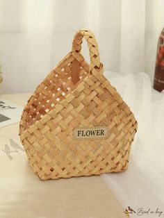 a woven basket sitting on top of a wooden table next to a bottle of wine