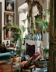 a living room filled with lots of furniture and paintings on the wall next to a fire place