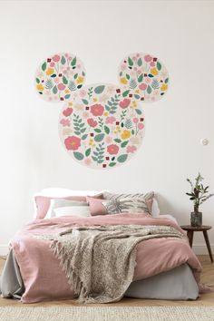 a bedroom with a mickey mouse wall decal on the wall and a bed in front of it