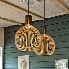 two wooden lamps hanging from the ceiling in a room with blue walls and wood paneling