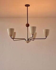 a chandelier hanging from the ceiling in a room with white walls and flooring