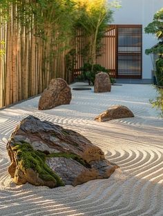 a rock in the middle of a garden with rocks and plants around it, surrounded by bamboo