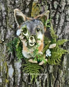 a stuffed animal is in the middle of a tree with flowers on it's head