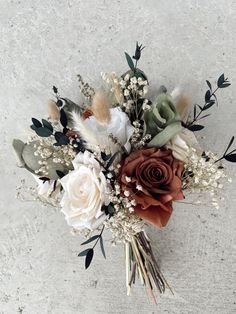 a bouquet of flowers sitting on top of a white table next to a gray wall