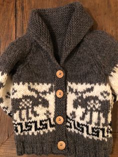 the sweater is knitted and has an animal motif on it, along with buttons