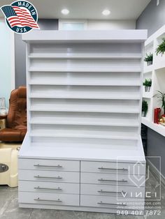 a large white bookcase with drawers in the middle and shelves on both sides, along with an american flag sticker above it