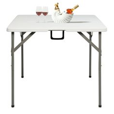 a white table with two wine glasses on it