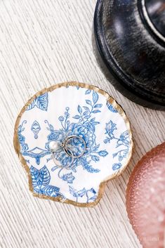 a blue and white plate sitting on top of a wooden table next to an old black pot