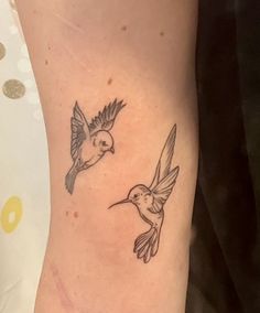 a couple of birds flying next to each other on a woman's right arm