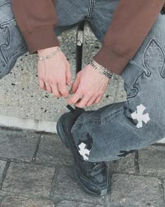 a person sitting on the ground tying their shoes