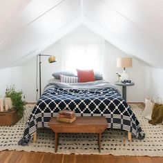 an attic bedroom with white walls and wood floors