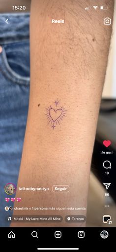 a person with a small tattoo on their arm and the word love is written in purple ink