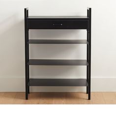 a black shelf with three shelves on each side and a white wall in the background