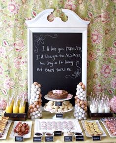 an assortment of desserts on a table with a chalkboard in the background that says i'll love you forever