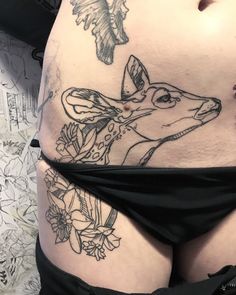 a woman's stomach with tattoos on it and a deer in the bottom half