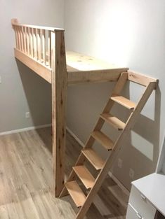 there is a wooden staircase next to the bed