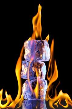 a stack of ice cubes sitting on top of a table covered in fire and flames