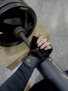 a woman is doing exercises with a barbell in her hand and wearing black leggings