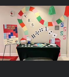 a black table topped with cards and dices next to a sign that says vbs