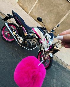 a person is pointing at a pink motorcycle