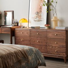 a bedroom scene with focus on the bed and dresser, which also has a mirror