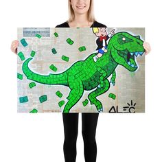 a woman holding up a poster with a cartoon dinosaur on it's back and money coming out of her mouth