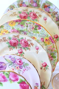 a bunch of plates that are stacked on top of each other with flowers painted on them