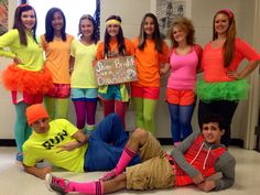 a group of young people dressed in costumes posing for a photo with one man laying on the floor