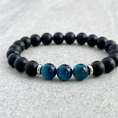 Men's beaded bracelet features: ~ 6mm, 8mm or 10mm matte onyx beads ~ 6mm, 8mm or 10mm aqua blue tiger eye beads ~ 4mm, 6mm or 8mm stainless steel spacers ~ Stretchy cord; simply slide bracelet on and off wrist ~ Comes packaged in a re-usable microfiber pouch To ensure the perfect fit, please use the bracelet sizing instructions found in the photo gallery. Male Bracelets Beads, Bead Bracelet Size Chart, Mens Gemstone Jewelry, Men’s Beaded Bracelets Diy, Male Bead Bracelet, Mens Beads Bracelet, Stone Bracelet For Men, Men’s Beaded Jewelry, Mens Bracelets Diy