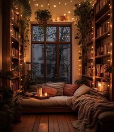 a cozy room with bookshelves and lights on the windowsill is lit up by candles