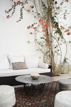 a living room with white furniture and flowers on the wall