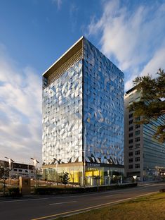 a large glass building sitting on the side of a road