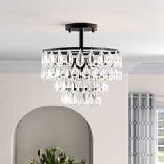 a chandelier hanging from the ceiling in a room with white walls and windows