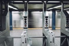 two turnsets in front of a closed door at a subway station with shutters