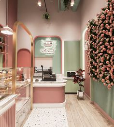 the interior of a pastry shop with pink and green walls, gold trimmings and floral decorations