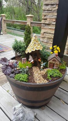 a potted planter filled with lots of plants and small houses on top of it