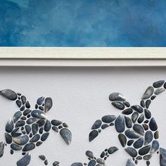 a sea turtle made out of seashells on a white wall