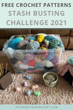 a plastic container filled with balls of yarn next to a pile of crochet needles