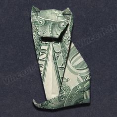 an origami cat made out of one hundred dollar bills on a black background