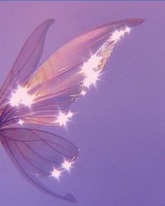 a butterfly flying through the air with its wings spread out and glowing stars on it's back