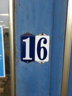 a blue door with two white numbers on it and a sign that says, 16