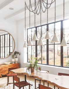 a dining room table with four chairs and a chandelier hanging from the ceiling