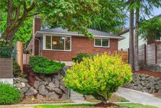 a home with landscaping and trees in the front yard