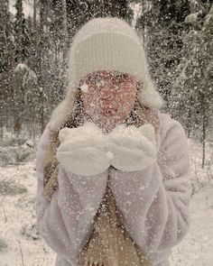 a woman standing in the snow covering her face