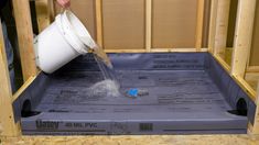 a person pouring water into a container from a box in the process of being built