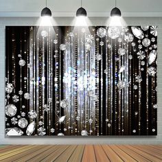 an empty room with three lights hanging from the ceiling and several crystal beads on the wall