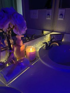 a lighted bathroom sink with candles and soap