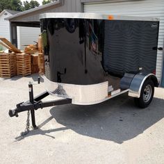 an enclosed trailer parked in front of a building