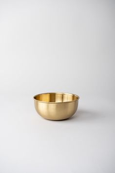 a gold bowl sitting on top of a white table