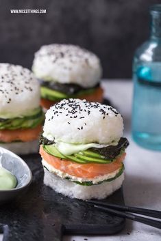 sushi sandwiches with cucumber, salmon and avocado on a black plate